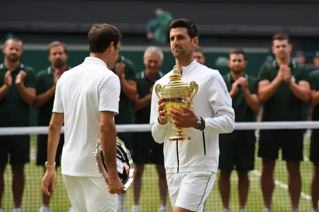 Novak Djokovic and Roger Federer with their trophies