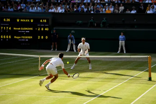 Novak Djokovic and Roger Federer trade shots at the net