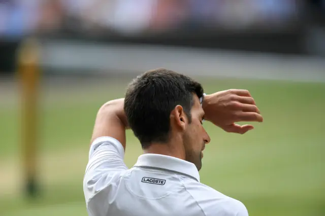 Novak Djokovic wipes his forehead