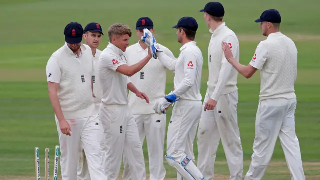 The England Lions players inspect the damage following Sam Curran's removal of Jackson Bird at Canterbury