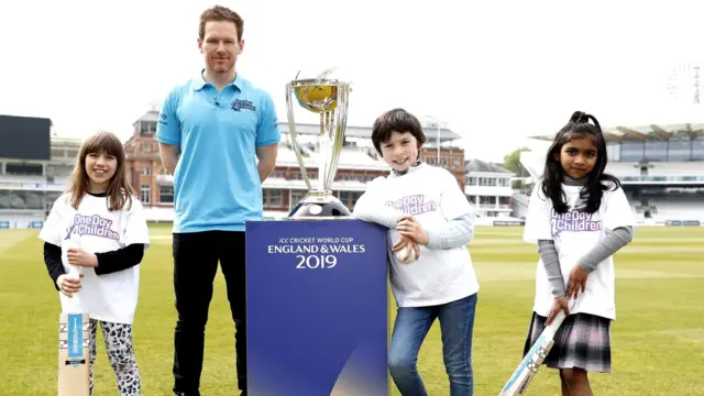 England captain Eoin Morgan with the Cricket World Cup and children interested in cricket