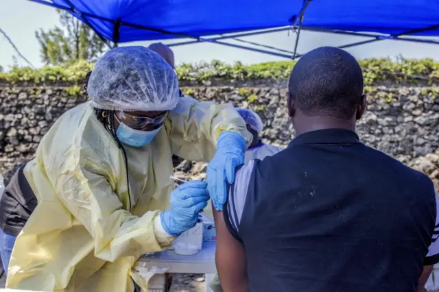 A man receives a vaccine against Ebola from a nurse outside the Afia Himbi Health Center on July 15,