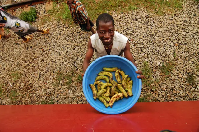 A man holding a bowl of bananas