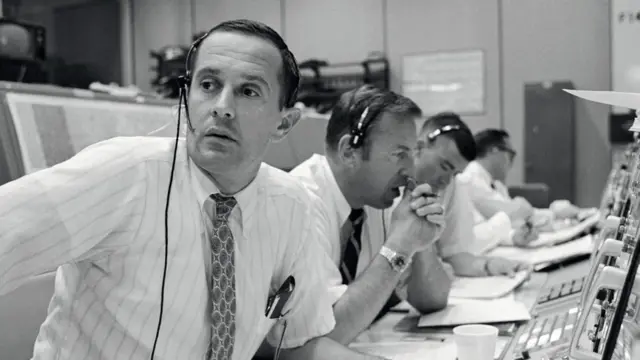 Charlie Duke sitting at a desk