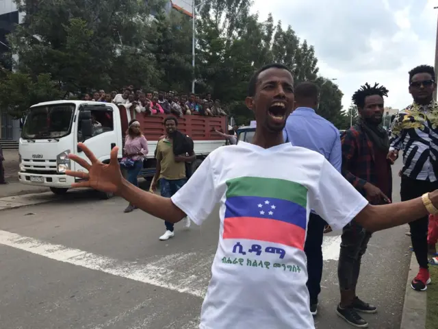 Man with a T-shirt with Sidama flag on it