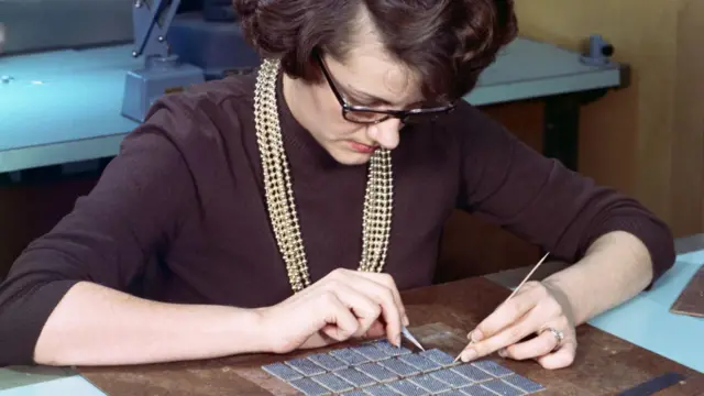 An engineer stringing the sense inhibiting wiring component of the Apollo Guidance Computer