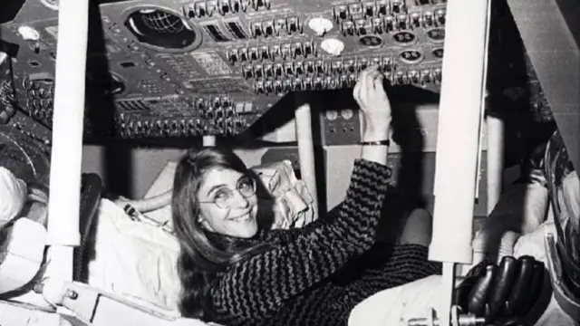 Margaret Hamilton holding a switch on a computer