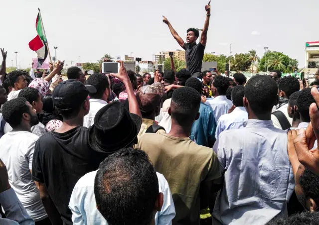 Sudanese protesters chant slogans and wave national flags as they march in the capital Khartoum's Green Square on July 18, 2019