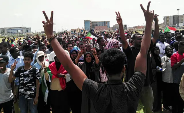 Sudanese protesters chant slogans and wave national flags as they march in the capital Khartoum's Green Square on July 18, 2019