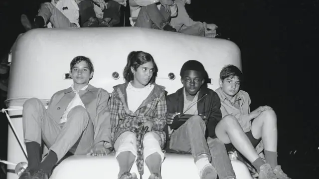 A group of children sit on a truck