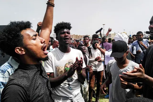 Sudanese protesters chant slogans and wave national flags as they march in the capital Khartoum's Green Square on July 18, 2019