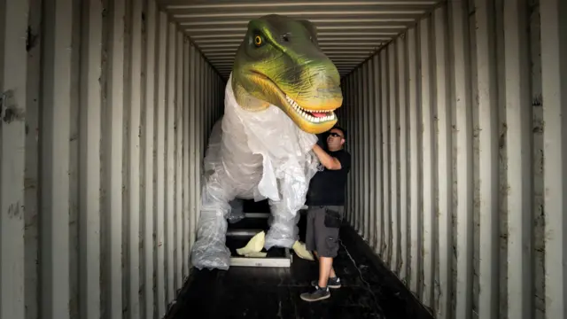 A dinosaur in a shipping container