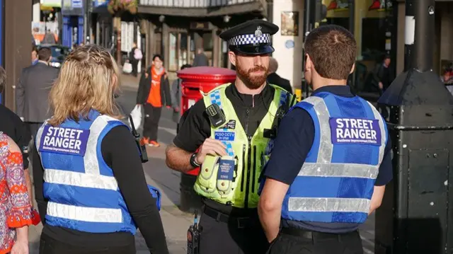 A police officer with two street rangers