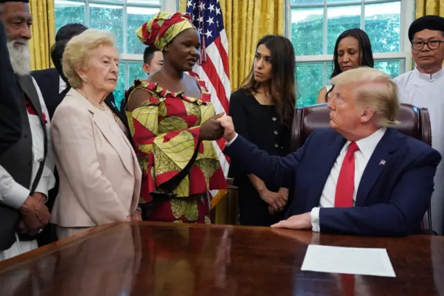 President Donald Trump shakes hands with Esther Bitrus, who was kidnapped by Boko Haram in 2014 in Nigeria,