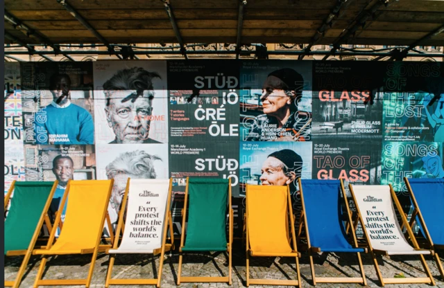 Deckchairs in the sun in front of festival posters