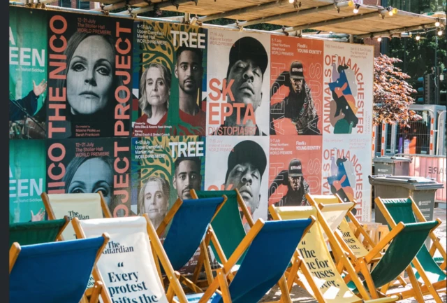 A wall covered in show posters, with deck chairs in front