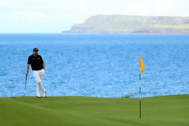 Shane Lowry on the fifth green with a dramatic backdrop