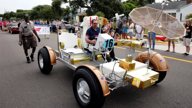 A detailed replica of the Lunar Rover Vehicle bring driven in a parade