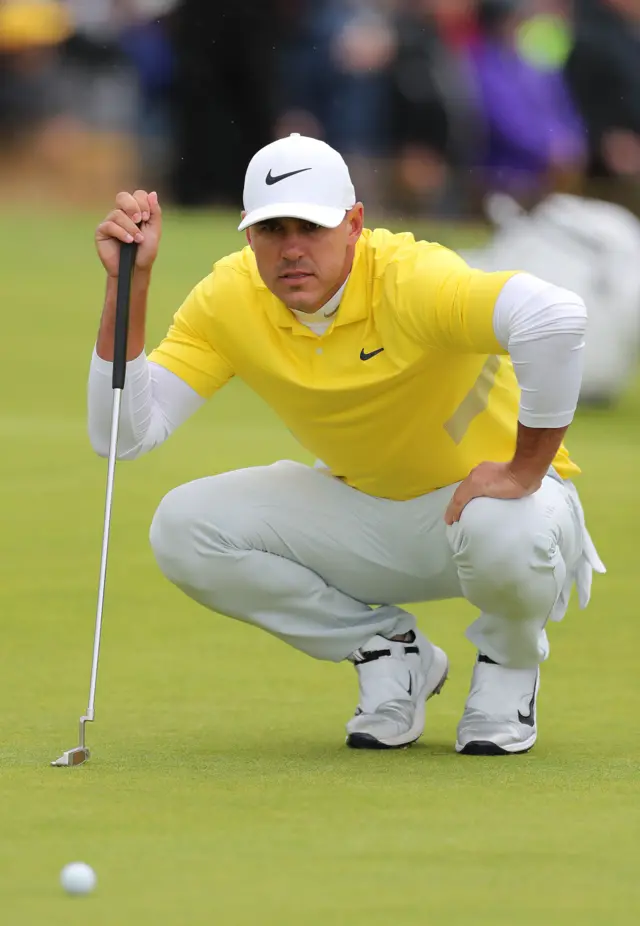 Brooks Koepka putts on the first hole