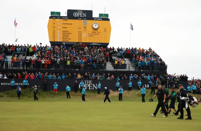 The grandstand roars as Shane Lowry walks up the 18th fairway