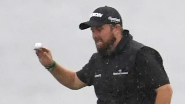 Shane Lowry putts in for a birdie on the fifth hole in worsening conditions