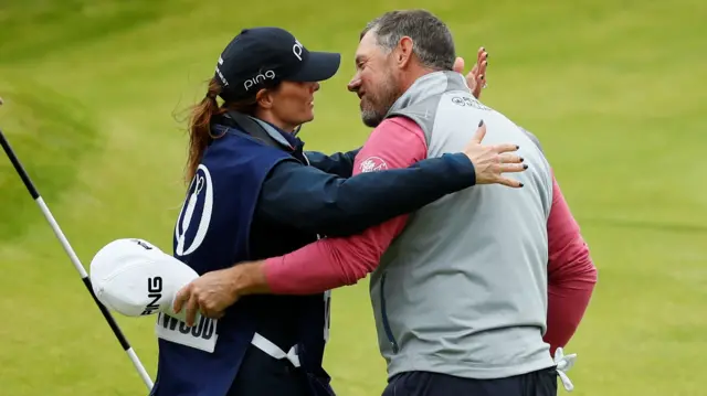 Lee Westwood and girlfriend Helen Storey - who has carried his bag this week - on the 18th green