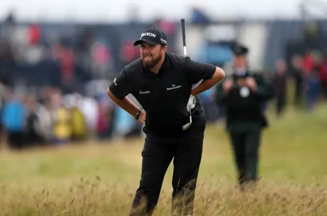 Shane Lowry hits out of deep rough into a bunker o the first hole