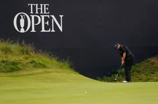 Shane Lowry rolls his final putt towards the hole on the 18th green