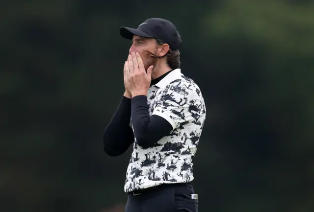 Tommy Fleetwood puts his head in his hands after carding a double bogey on the 14th hole