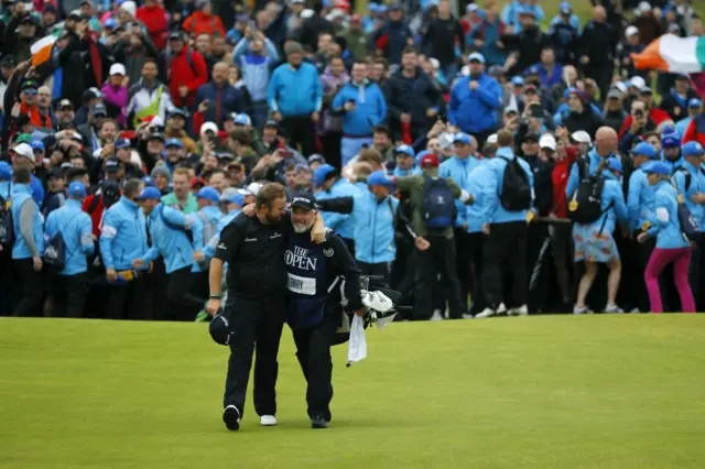 Shane Lowry and his caddie Brian Martin walk down the 18th fairway