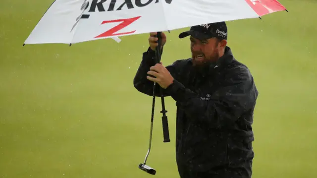 Shane Lowry with his umbrella and putter