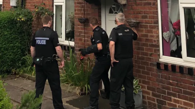 Police officers outside a house in the Moorlands