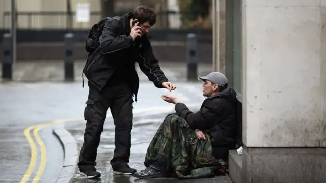 Man giving money to a street begger