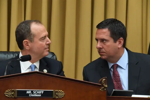 House Intelligence Committee Chairman Adam Schiff (L) speaks with committee member Devin Nunes