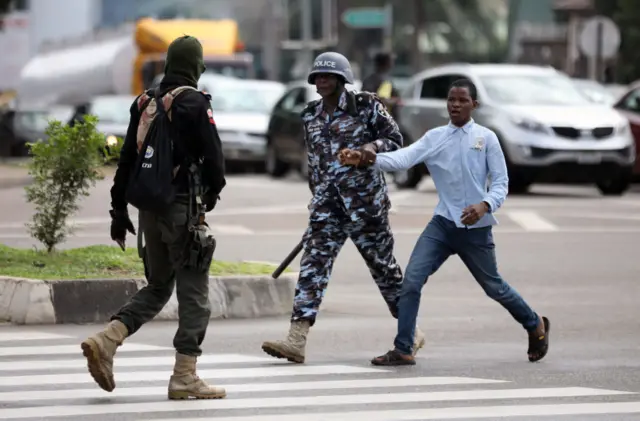 A policeman arrests a man for questioning during a violent protest of Shiite Muslims demanding the release of their detained leader Ibrahim Zakzak