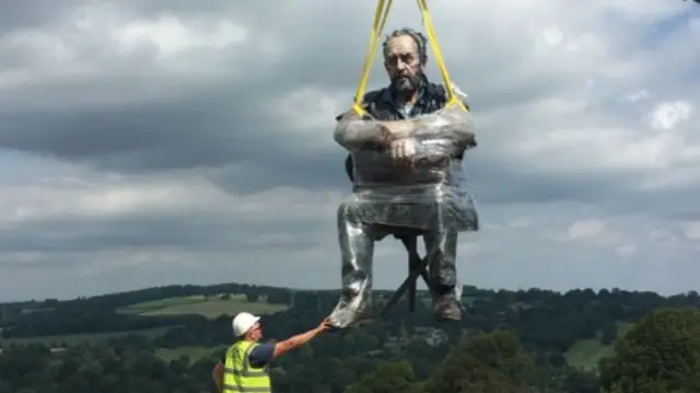 The Seated Figure being lowered into place