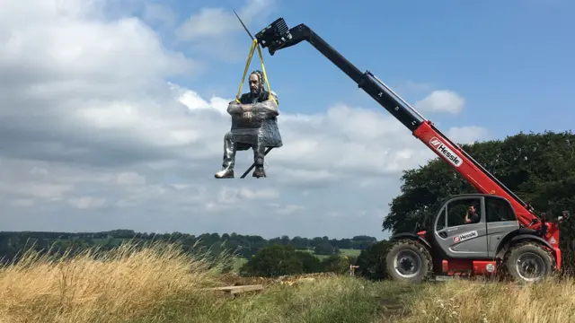 The Seated Figure being lowered into place