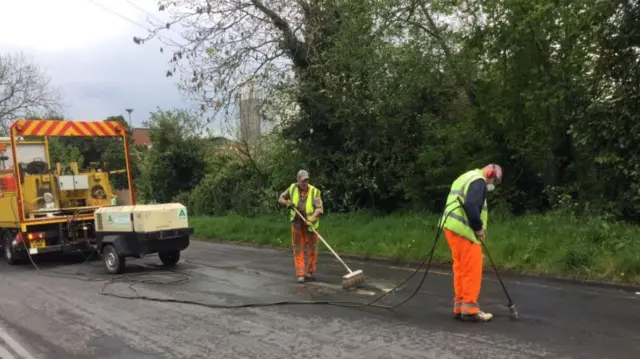 Workmen removing graffiti