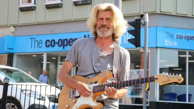 Dave, playing his guitar in Stoke-on-Trent