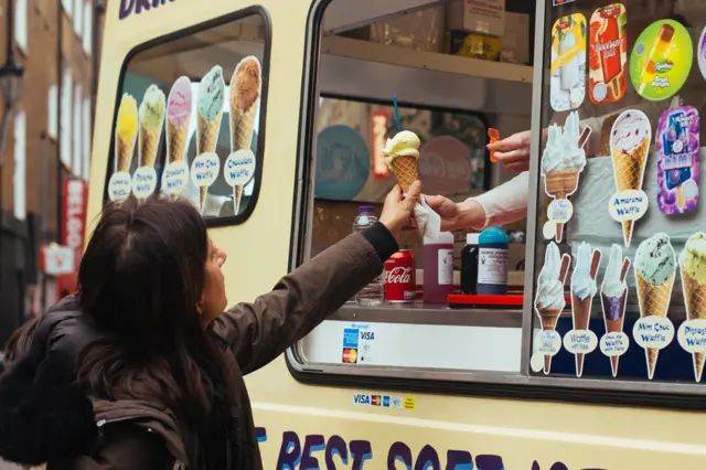 Woman buying an ice cream from a van