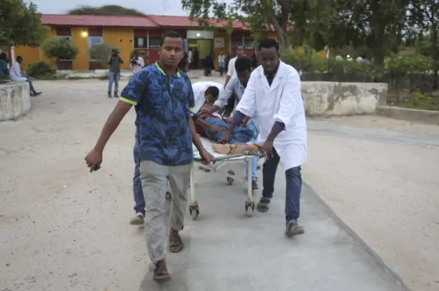 People pulling a hospital trolley