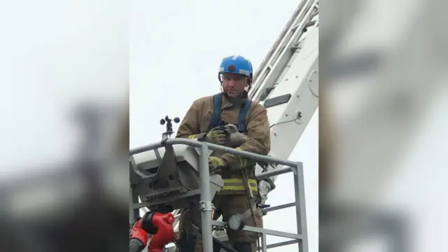 A firefighter with the young seagull