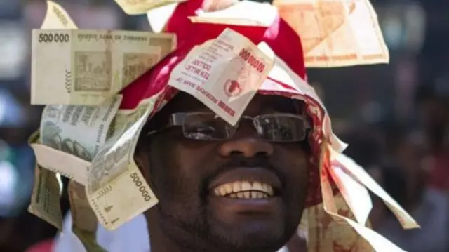 Man with currency notes stuck on his head