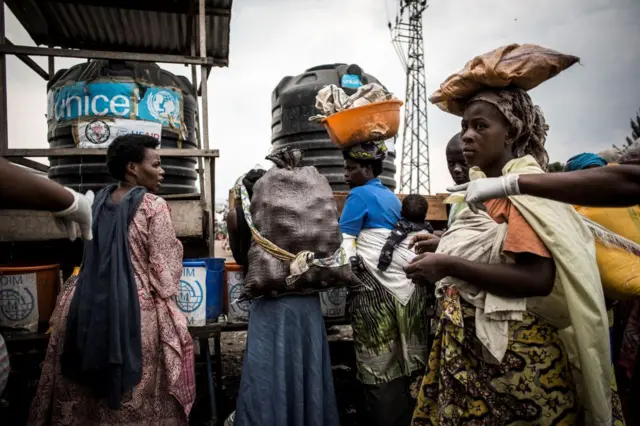 Women are seen washing their hands at an Ebola screening station as they enter the Democratic Republic of the Congo from Rwanda on July 16, 2019 in Goma