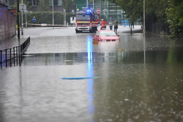 A car stranded in flood water in Crossley Road in Manchester,