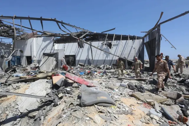 Migrants check the rubble of a destroyed detention center in Tripoli"s, Libya, 03 July 2019.