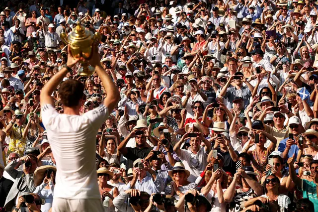Murray holds up the Wimbledon trophy to the crowd