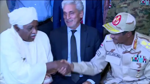 Military and civilian leaders shaking hands