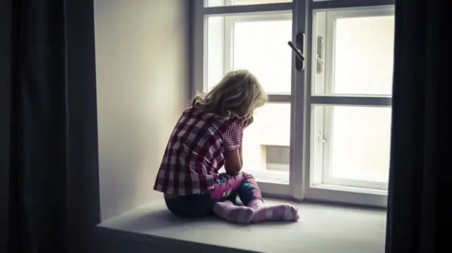 Child sitting in window