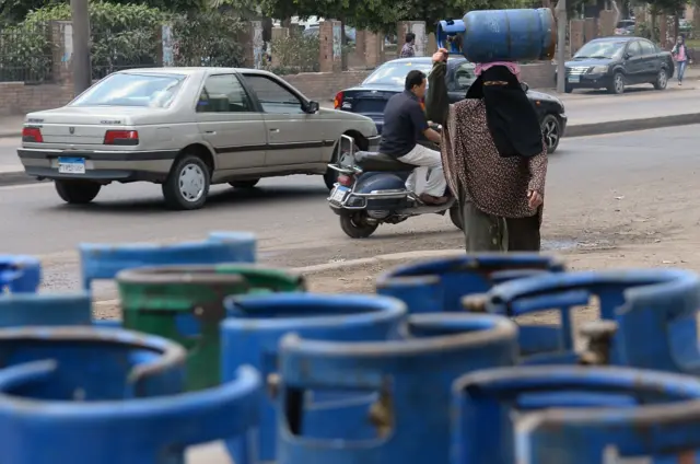 Woman holding cooking gas cylindar